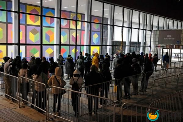 A group of migrants from various countries standing in line outside 26 Federal Plaza in downtown Manhattan, waiting to enter the ICE entrance.