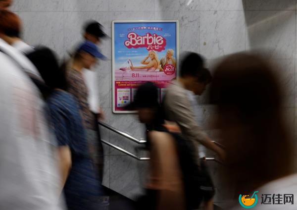 People walk past a a promotio<em></em>nal poster of 