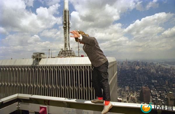 French high wire artist Philippe Petit takes a walk along the railing of one of the World Trade Center Towers high above New York City on July 14, 1986. 