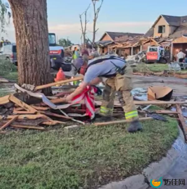 Andrew Skipper taking a moment to rescue the American flag from debris following the deadly tornado.