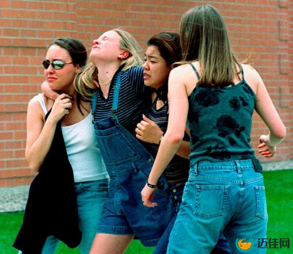 Young women head to a library near Columbine High School wher<em></em>e students and faculty members were evacuated after two gunmen went on a shooting rampage in the school 