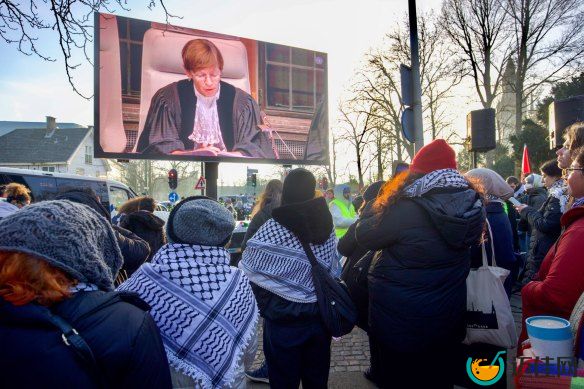 Pro-Palestinian demo<em></em>nstrators watch proceedings at the ICJ on a large screen in The Hague, Netherlands.
